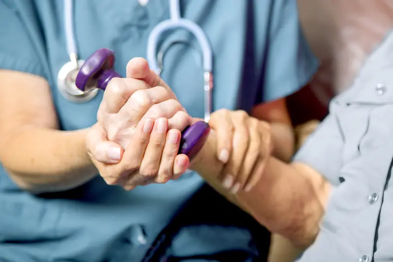 Physiotherapist treating a patient's wrist at the clinic